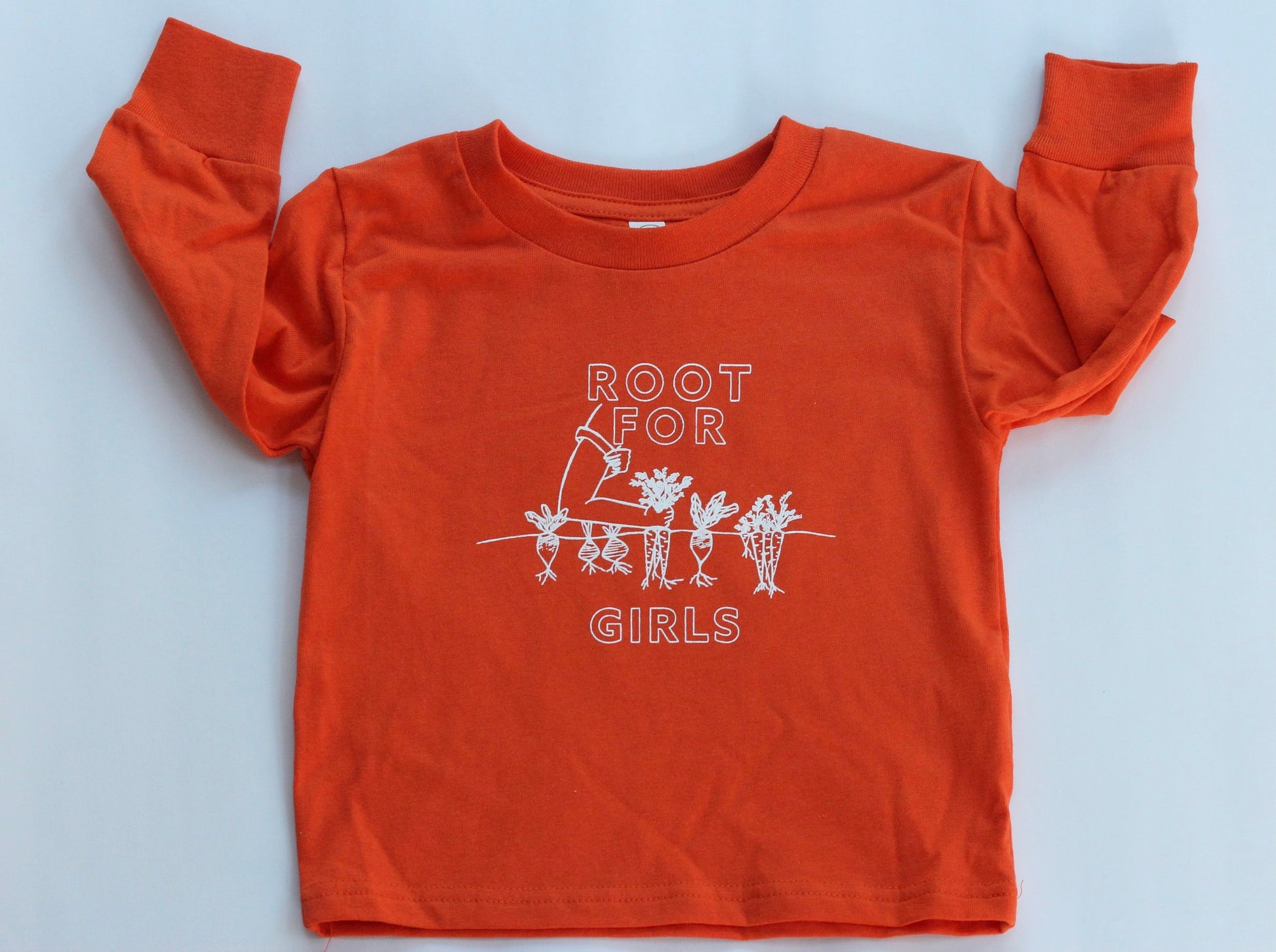 A carrot orange long sleeve toddler tee reads "Root for Girls" in white block letters